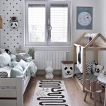 Ahşap mobilyalar ve beyaz duvarlarla dekore edilmiş İskandinav bebek odası
