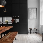 masif ahşap yemek masası ve ahşap laminat zemin ile mat siyah mutfak