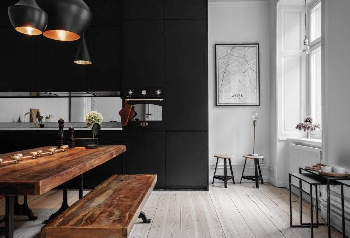 masif ahşap yemek masası ve ahşap laminat zemin ile mat siyah mutfak