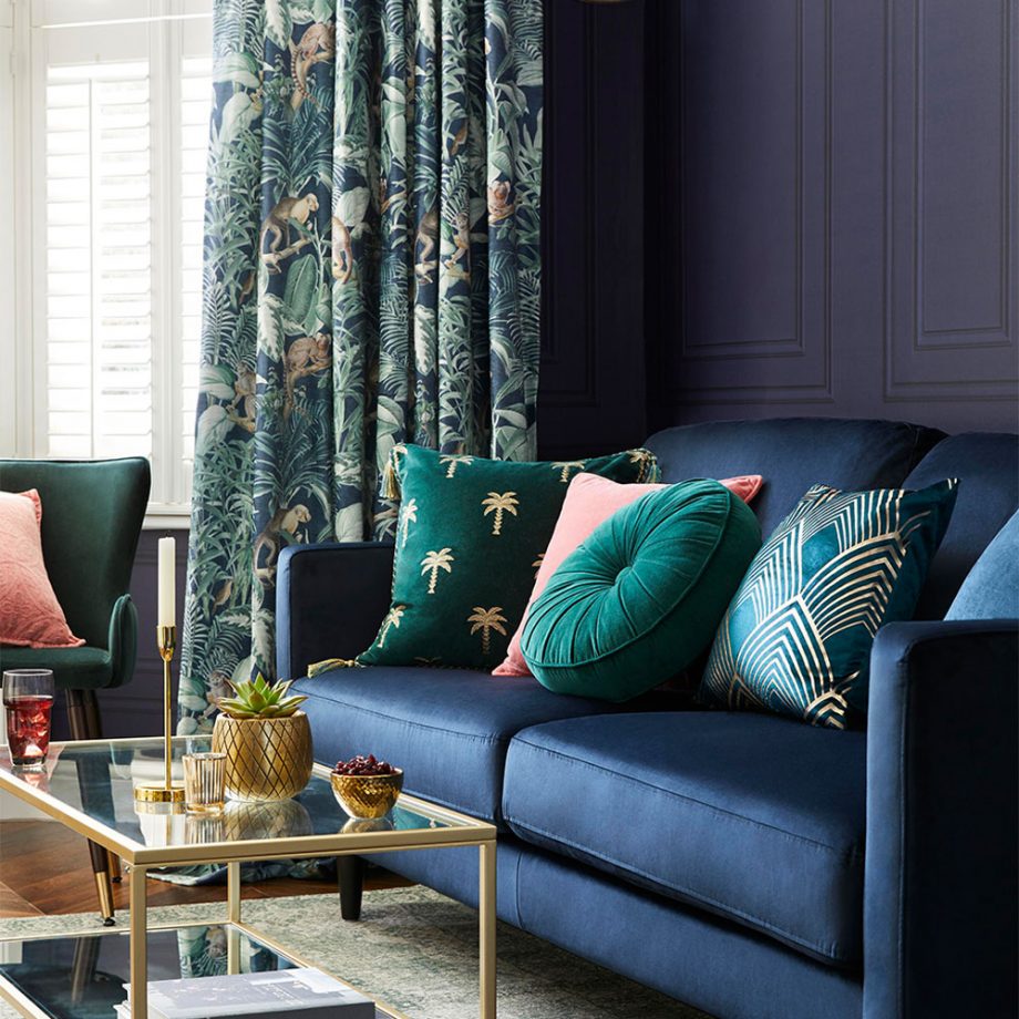 Çiçekli perdeler ve mavi kanepe ile oturma odası