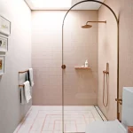 Pembe fayanslı ve kavisli ekranlı duş odası