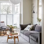 Gri kanepe ve beyaz duvarlı İskandinav oturma odası tasarımı