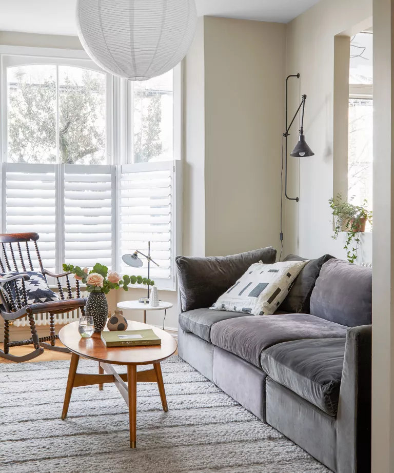 Gri kanepe ve beyaz duvarlı İskandinav oturma odası tasarımı