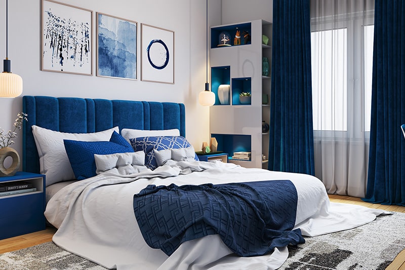 Beyaz boyalı duvarlar ve klasik mavi yatak başlıkları ile yatak odası renk kombinasyonu